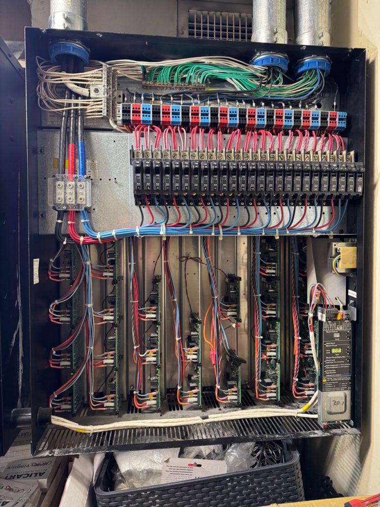 Panel de control eléctrico comercial abierto con cableado agrupado y breakers